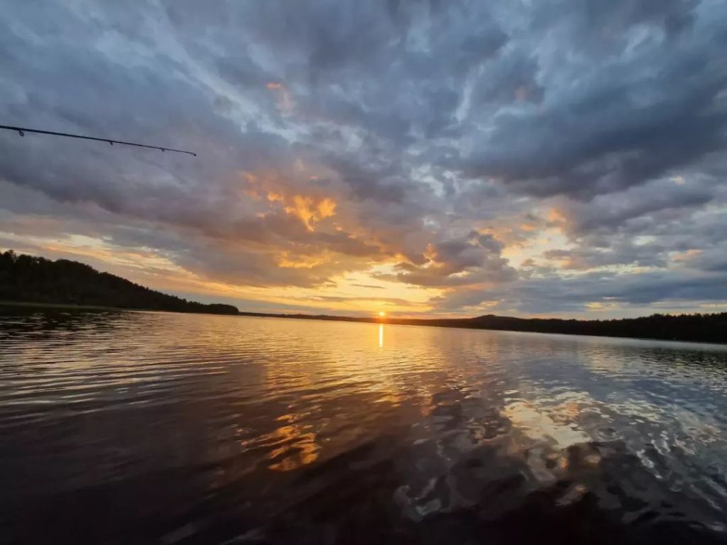Lake in Sweden with fishing rod and sunset